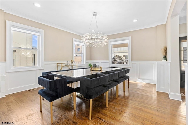 107 S Austin Ave, Ventnor, NJ 08406 - dining area featuring a chandelier, a wainscoted wall, a decorative wall, light wood-type flooring, and ornamental molding