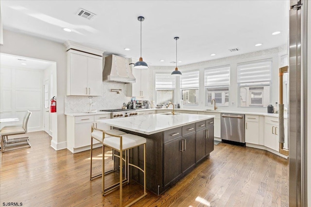 107 S Austin Ave, Ventnor, NJ 08406 - kitchen with dishwasher, custom range hood, white cabinets, wood finished floors, and a center island with sink