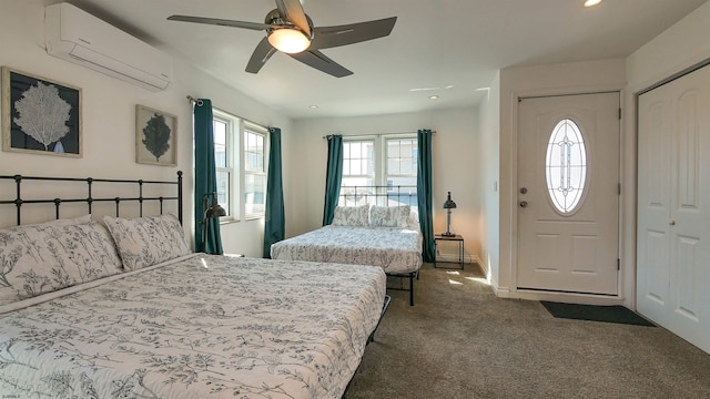 carpeted bedroom featuring a wall unit AC and ceiling fan