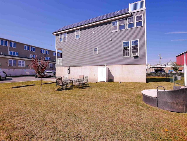 back of house with solar panels, cooling unit, a patio, and a lawn