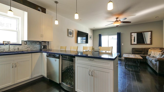 kitchen featuring dark wood-type flooring, kitchen peninsula, beverage cooler, and decorative light fixtures