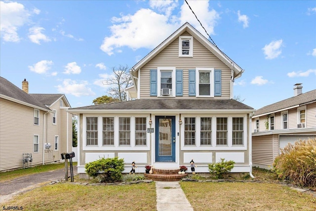 view of front of property featuring a front yard and a sunroom