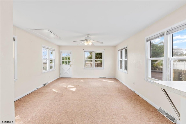 spare room featuring plenty of natural light, ceiling fan, and light carpet