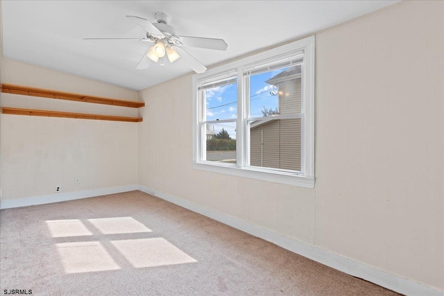 carpeted spare room featuring lofted ceiling and ceiling fan