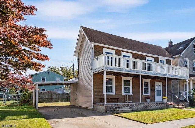 view of front of house featuring a balcony and a front lawn