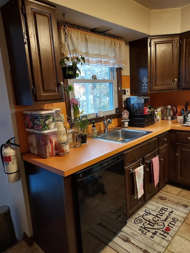 kitchen with dark brown cabinetry, sink, and black dishwasher