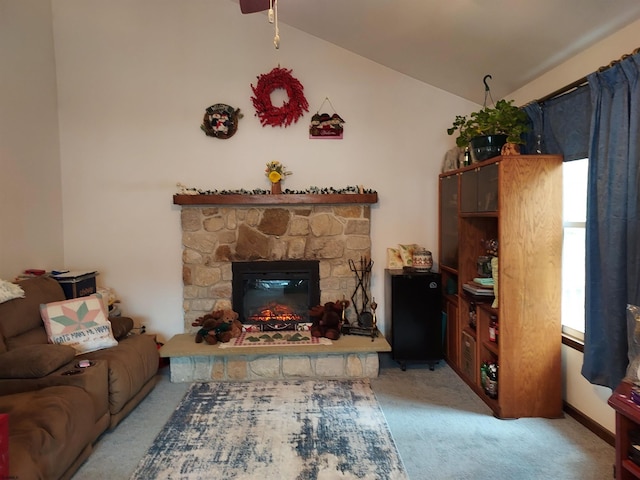 carpeted living room with a stone fireplace and lofted ceiling