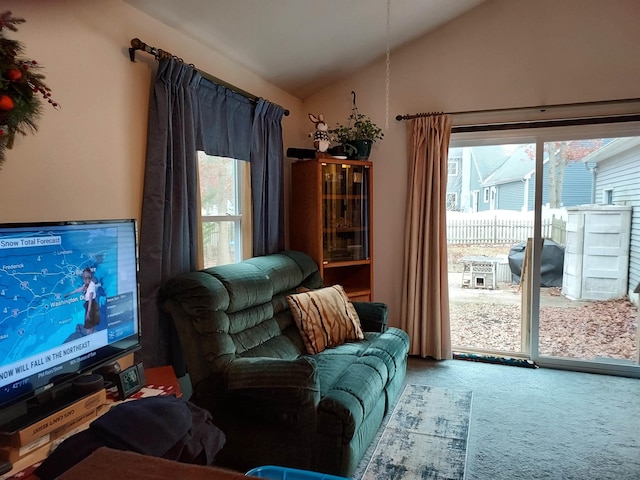 living room featuring vaulted ceiling, a healthy amount of sunlight, and carpet flooring