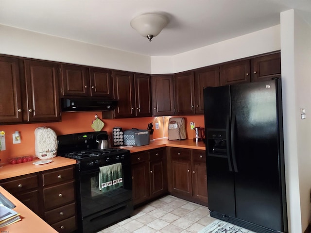 kitchen with dark brown cabinetry, light tile patterned floors, and black appliances