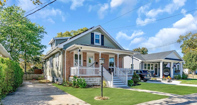 bungalow-style home with a front lawn and covered porch