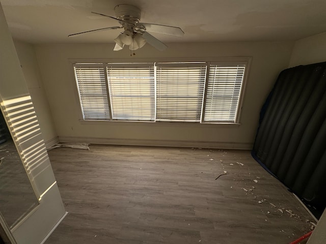 empty room with ceiling fan and hardwood / wood-style flooring