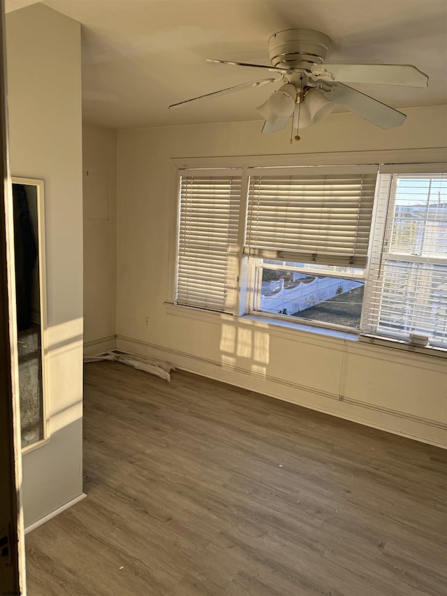 empty room with dark wood-type flooring and ceiling fan