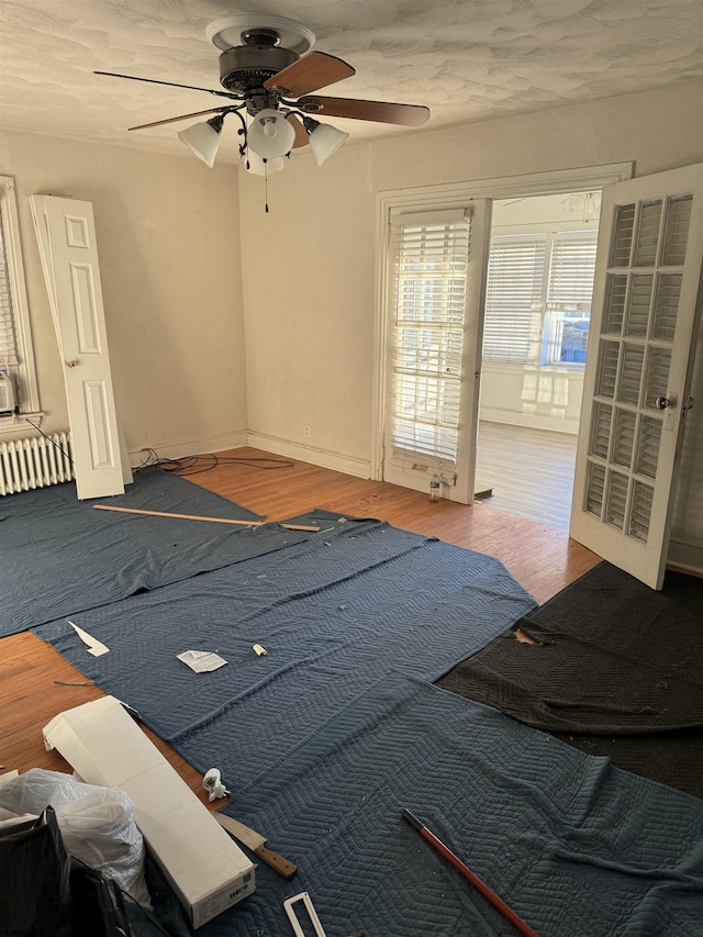 unfurnished bedroom with radiator, hardwood / wood-style flooring, and ceiling fan