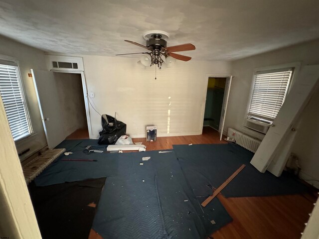 interior space featuring plenty of natural light, radiator, and wood-type flooring