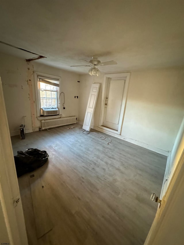 unfurnished room with ceiling fan, radiator, and hardwood / wood-style floors