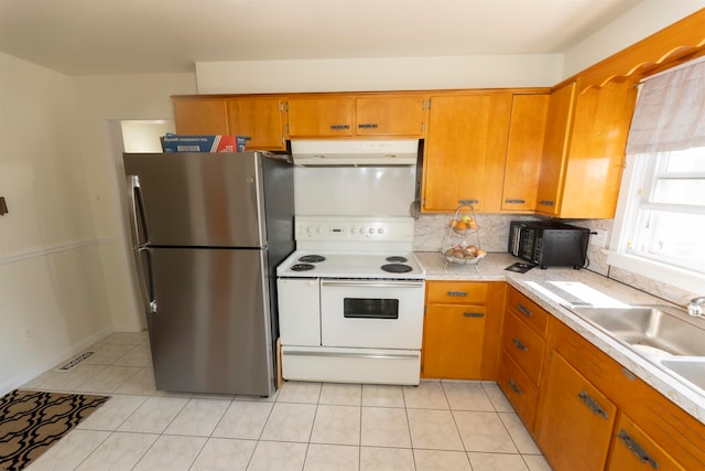 kitchen with decorative backsplash, stainless steel fridge, sink, light tile patterned flooring, and electric range