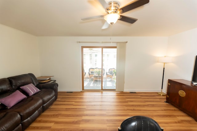 living room with ceiling fan and light hardwood / wood-style flooring