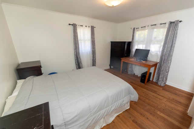 bedroom with hardwood / wood-style flooring and crown molding