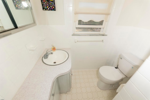 bathroom with tile walls, vanity, and toilet