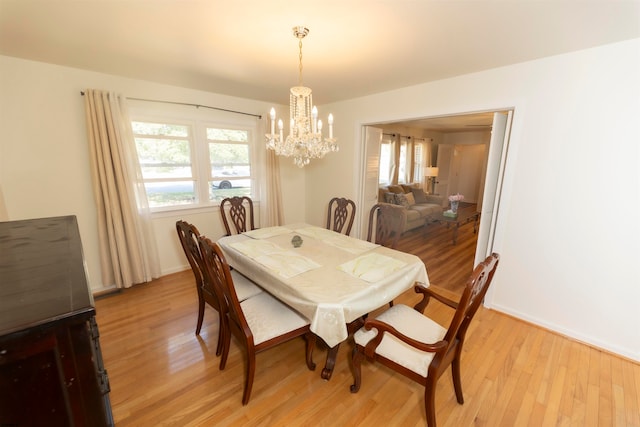 dining space featuring light wood-type flooring and a notable chandelier