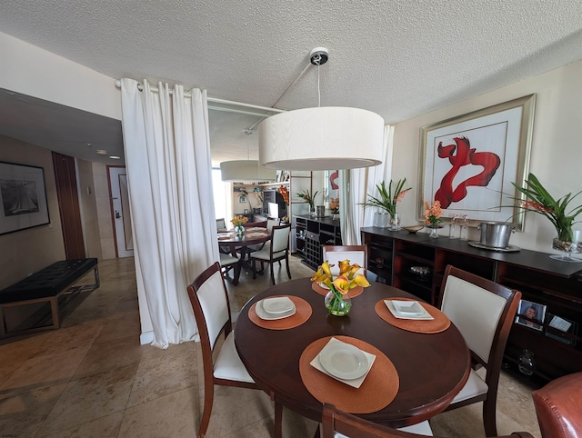 dining area with a textured ceiling and tile patterned flooring