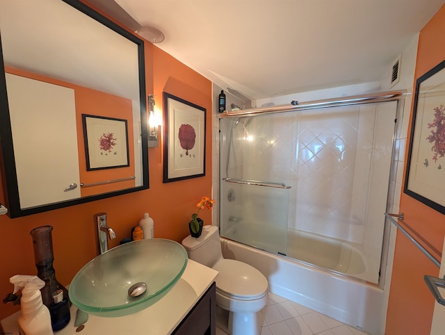 full bathroom featuring vanity, combined bath / shower with glass door, toilet, and tile patterned floors