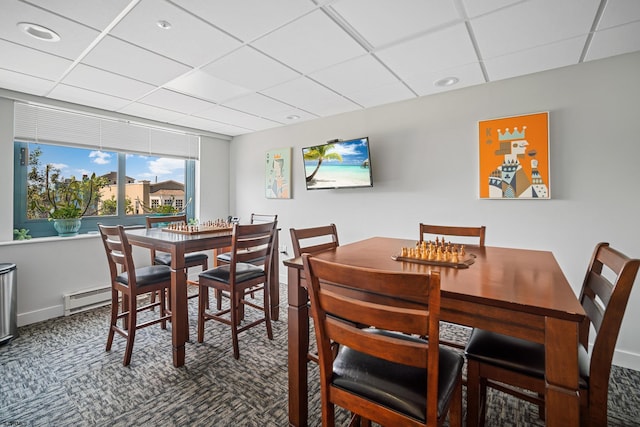 dining space featuring baseboard heating, a drop ceiling, and carpet floors