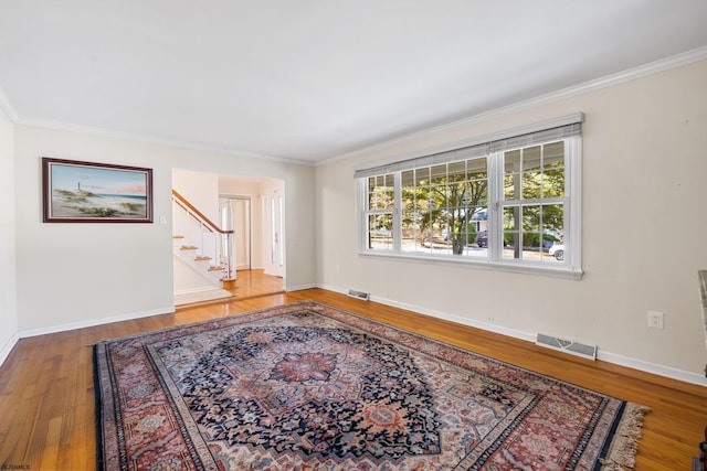 empty room with crown molding and wood-type flooring