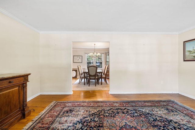 interior space with ornamental molding, a notable chandelier, and hardwood / wood-style flooring