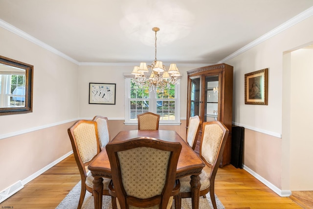 dining space featuring a wealth of natural light, a chandelier, light hardwood / wood-style flooring, and crown molding