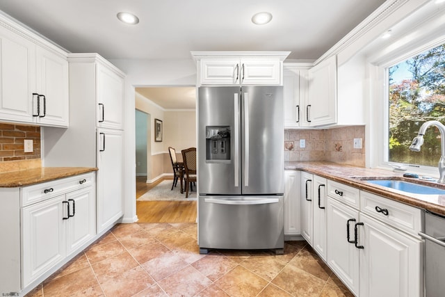 kitchen with stone counters, stainless steel appliances, decorative backsplash, and white cabinets