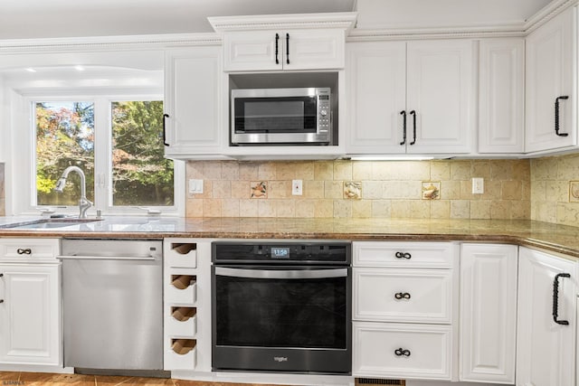 kitchen with tasteful backsplash, sink, stone countertops, stainless steel appliances, and white cabinets