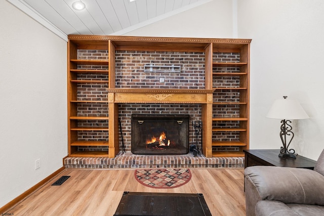 living room featuring hardwood / wood-style flooring, wooden ceiling, lofted ceiling, and a brick fireplace