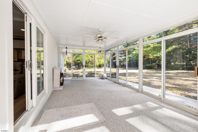 unfurnished sunroom with ceiling fan