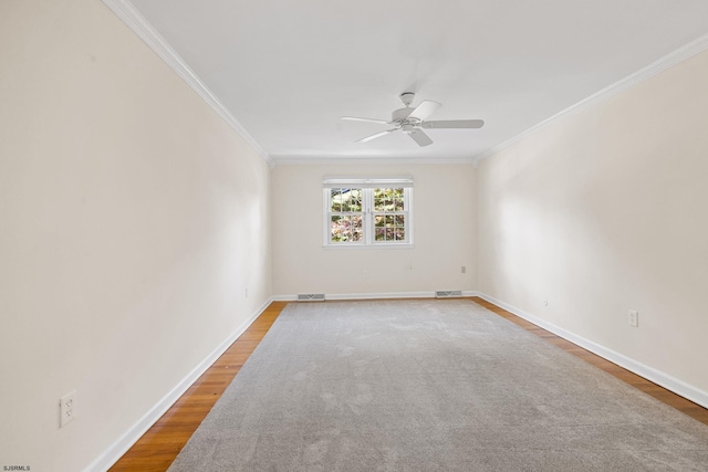 empty room with crown molding, wood-type flooring, and ceiling fan