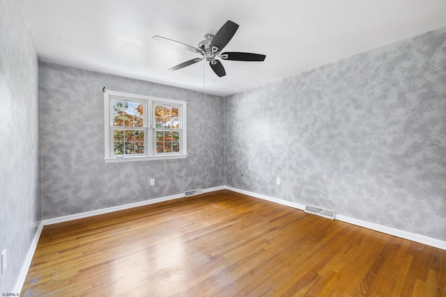 empty room with ceiling fan and wood-type flooring