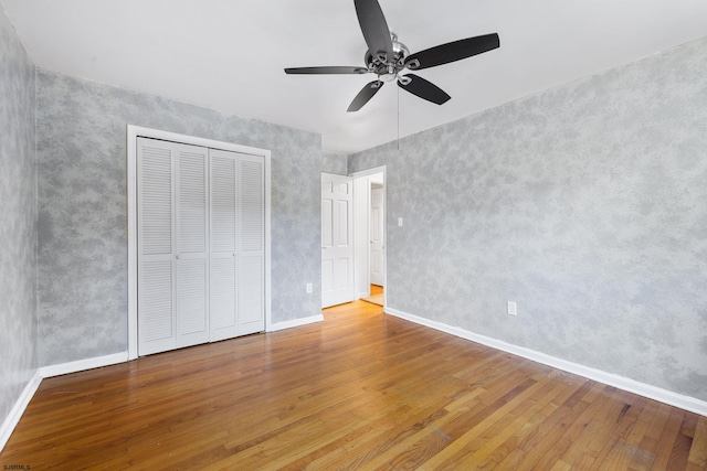 unfurnished bedroom with a closet, ceiling fan, and hardwood / wood-style floors