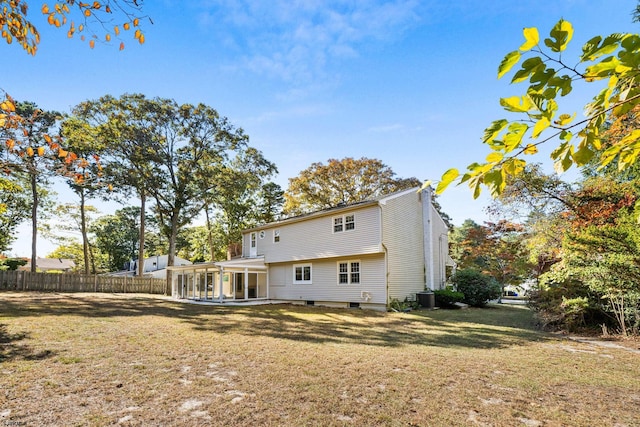 rear view of property featuring central AC, a patio, and a lawn