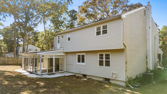 rear view of property with central air condition unit, a patio, and a sunroom