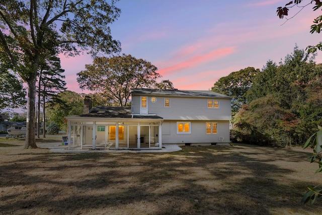 back house at dusk with a patio area