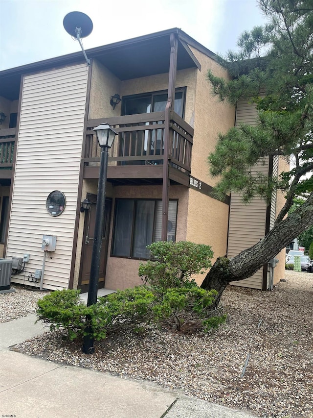 view of side of home with a balcony and central air condition unit