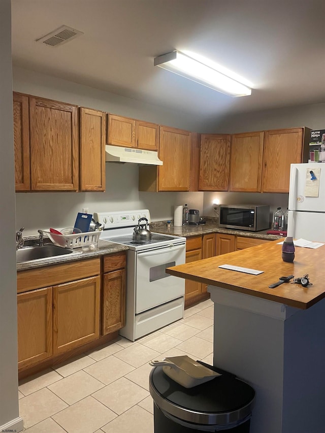 kitchen featuring light tile patterned flooring, sink, and white appliances