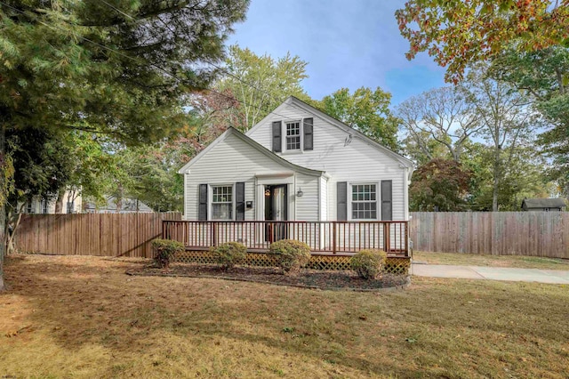 view of front facade with a wooden deck and a front yard