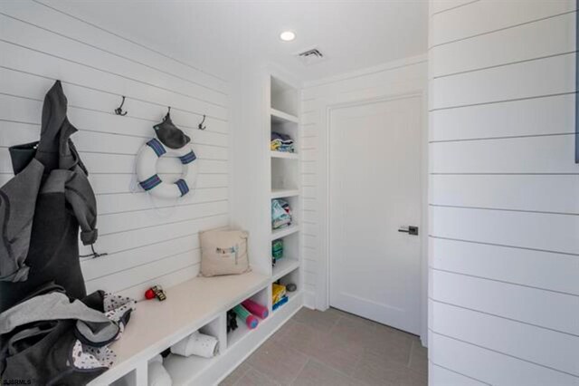 mudroom with wood walls