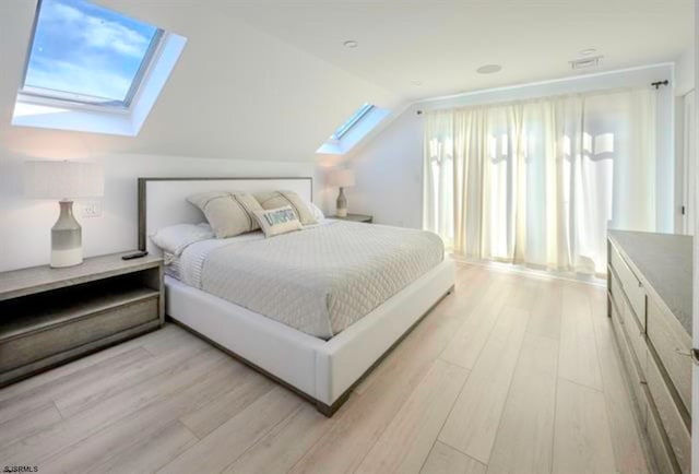 bedroom featuring light hardwood / wood-style floors and lofted ceiling