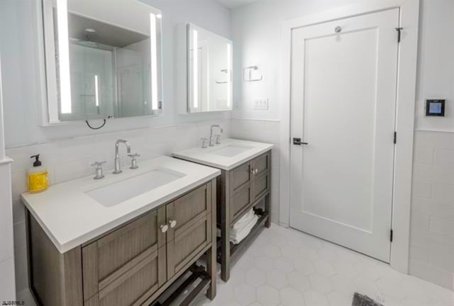 bathroom with tile patterned flooring, vanity, and tile walls