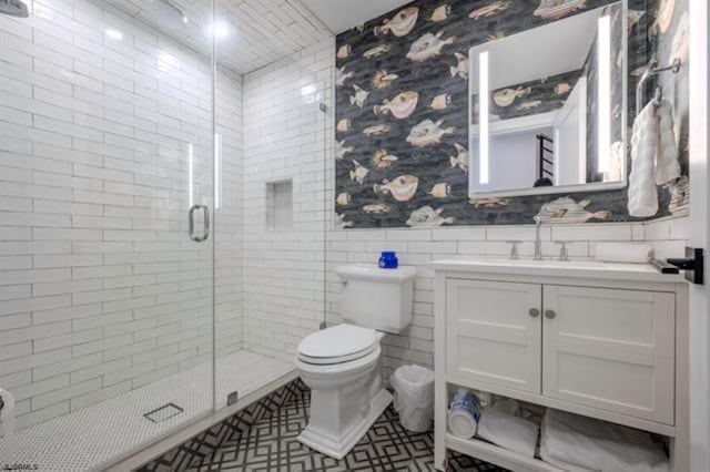 bathroom with toilet, vanity, tile walls, and walk in shower