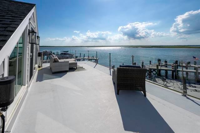 view of patio featuring a water view and a dock