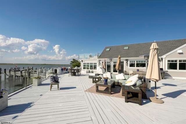 deck featuring outdoor lounge area and a water view