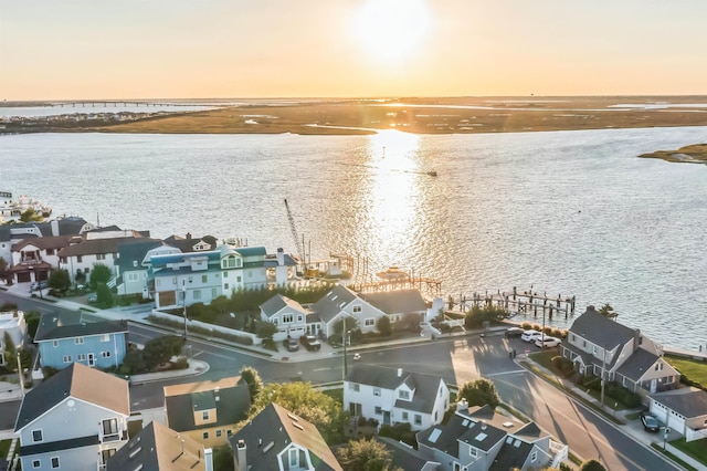 aerial view at dusk featuring a water view